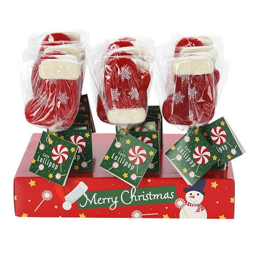 Des sucettes, en forme de gants et de chaussettes de Noël, qui tiennent debout sur un carton rouge « Merry Christmas ». Le tout sur un fond blanc