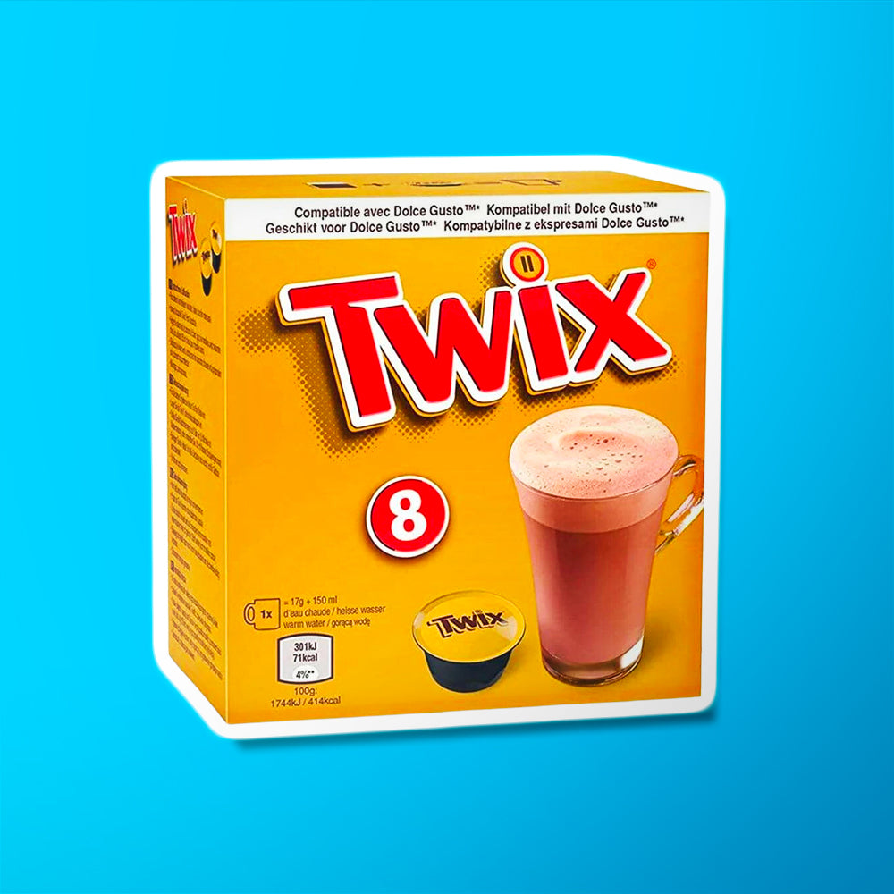 Un carton doré sur fond bleu avec écrit en grand « Twix » en rouge. Sur le devant, il y a une capsule Twix noir et doré et à droite une grande tasse transparente avec du chocolat chaud