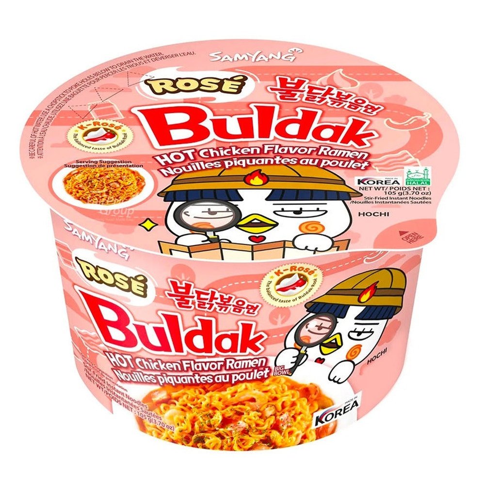 Un emballage en bol rose sur fond blanc avec une grande assiette blanche de nouilles oranges et à droite une créature blanche qui regarde l’assiette à la loupe