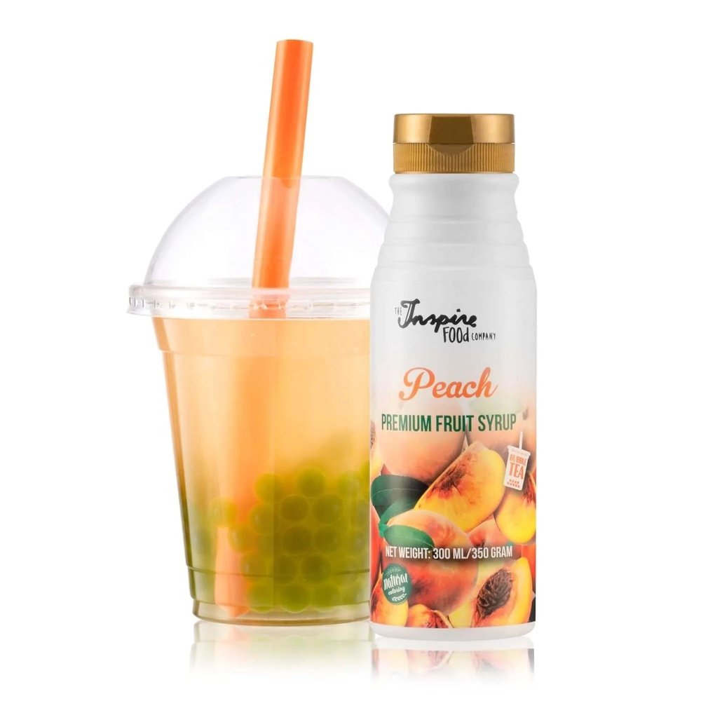A gauche un gobelet et un paille orange avec une thé orange avec des billes vertes. Et à droite une bouteille blanche avec des pêches, le tout sur fond blanc
