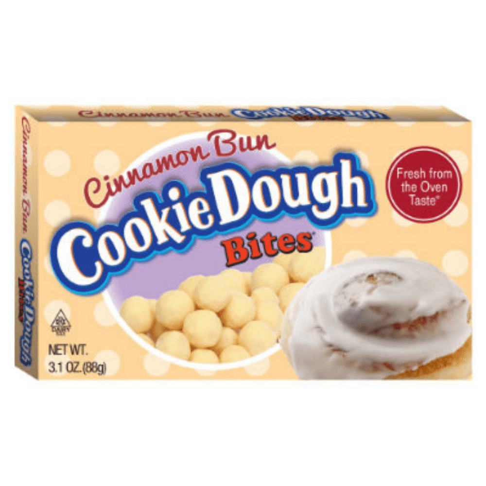 Un carton beige sur fond blanc avec des boules couleur crème et à droite un beignet couvert d’une glaçage blanc