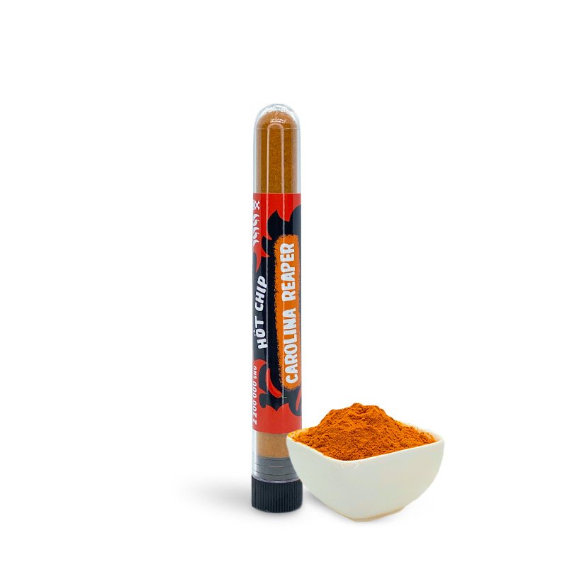 Une petite fiole transparente remplie d’une poudre orange avec une étiquette rouge et noire, devant il y a un petit bol avec la même poudre orange. Le tout sur fond blanc