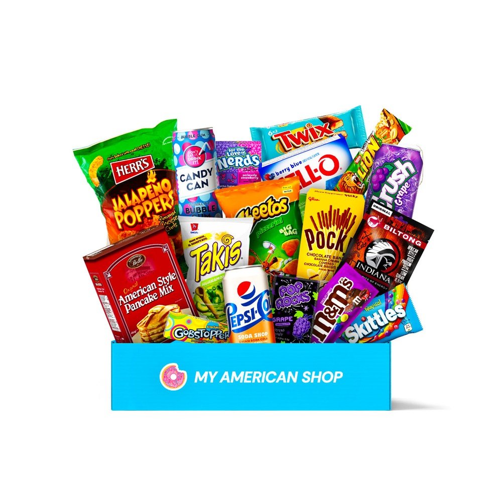 Un carton rectangulaire bleu contenant plein de snacks comme des biscuits en bâtonnet avec du chocolat jaune, un carton rouge de pancakes, un paquet mauve de M&M’s etc… Le tout sur fond blanc