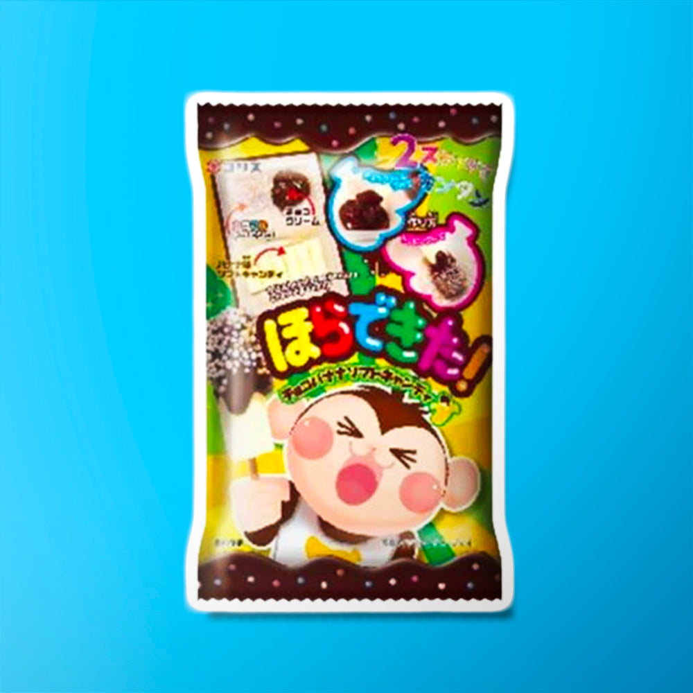 Un paquet coloré aux extrémités marrons avec un petit singe qui tient un glace avec du chocolat et des perles claires, le tout sur fond bleu