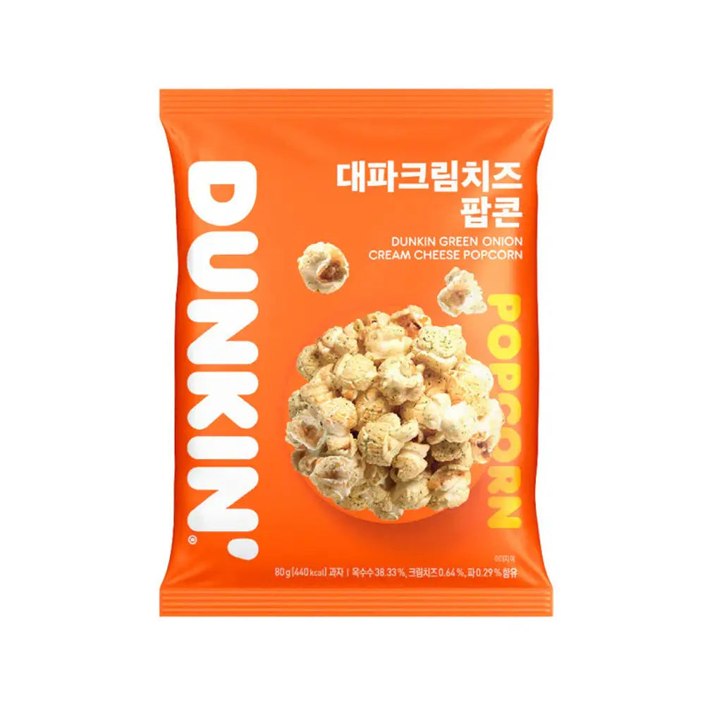 Un paquet orange sur fond blanc avec des popcorns couleur crème