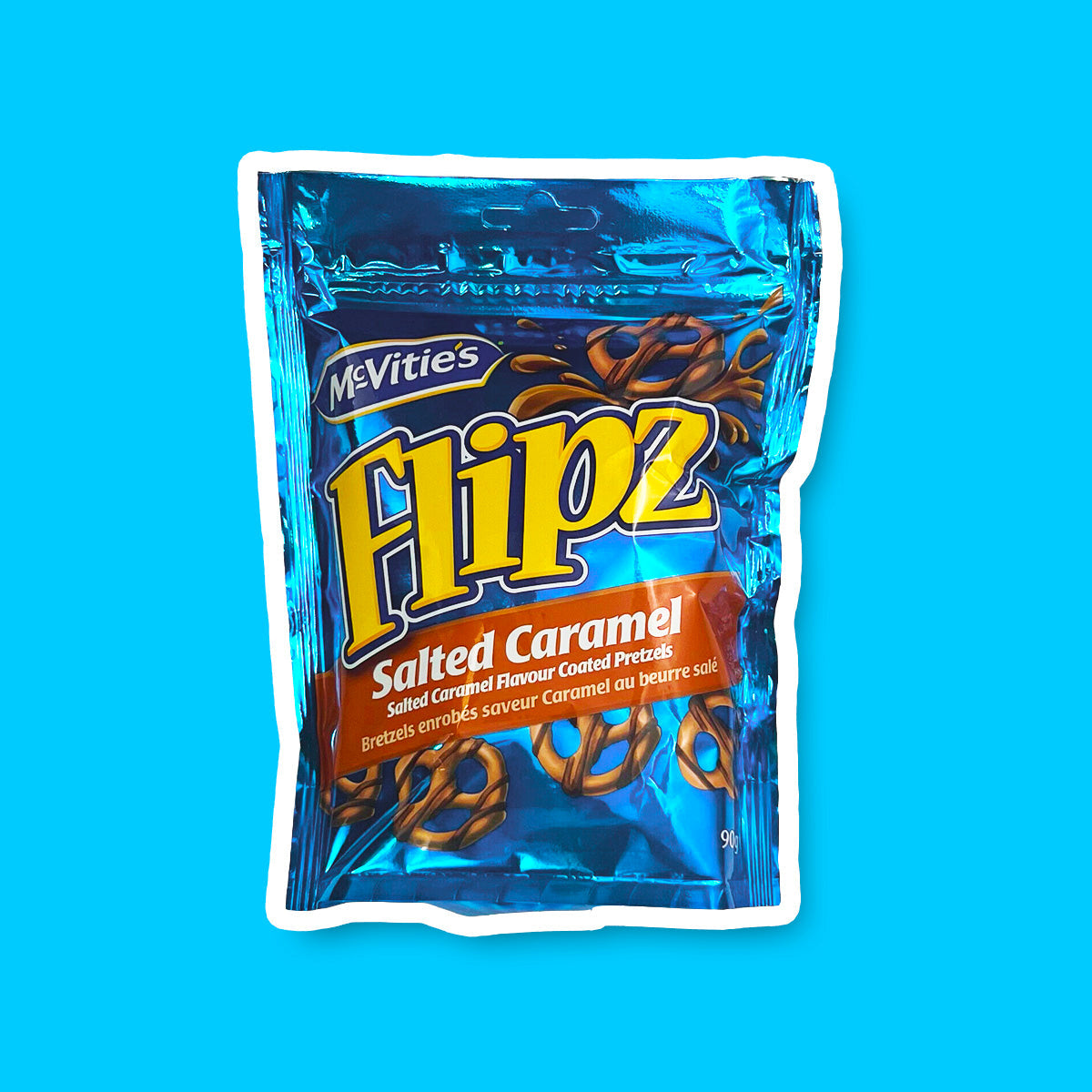 Un emballage bleu brillant sur fond bleu, avec 5 petits bretzels bruns dont un en haut à gauche avec une éclaboussure de caramel 