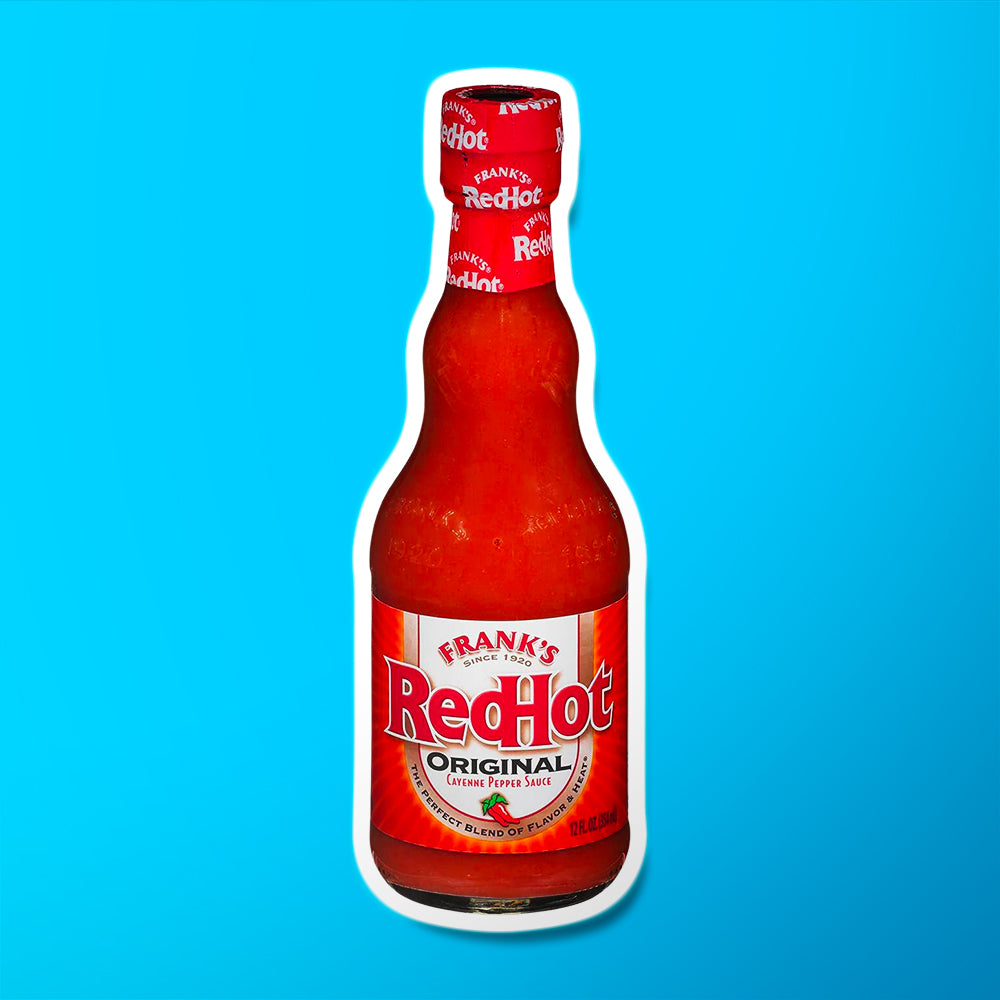 Une bouteille transparente avec une sauce rouge sur fond bleu et une étiquette rouge avec écrit « RedHot » en grand et en-dessous le dessin de 2 petits piments de Cayenne