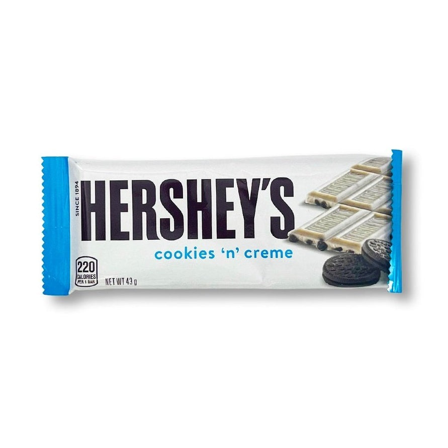 Un paquet blanc avec à droite une barre chocolatée Hershey’s Cookies & Cream et sur le devant 2 cookies noirs, le tout sur un fond blanc