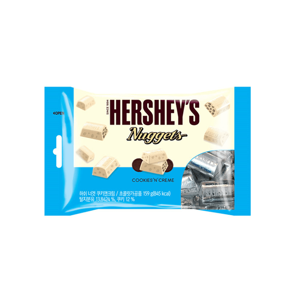Un emballage bleu et blanc sur fond blanc avec des morceaux de chocolats blancs