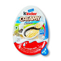 Un paquet blanc et orange sur fond blanc avec au centre un Kinder Creamy ouvert, on y voit le riz soufflé dans sa crème