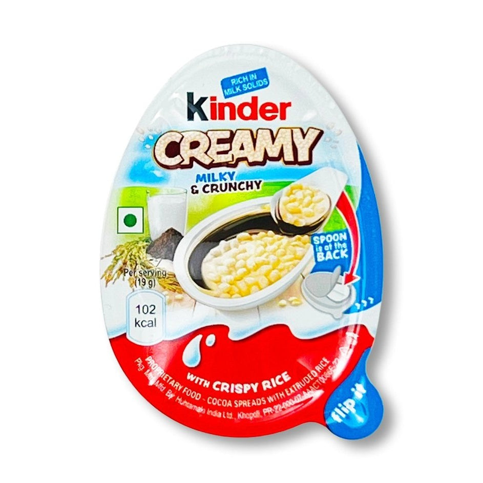 Un paquet blanc et orange sur fond blanc avec au centre un Kinder Creamy ouvert, on y voit le riz soufflé dans sa crème