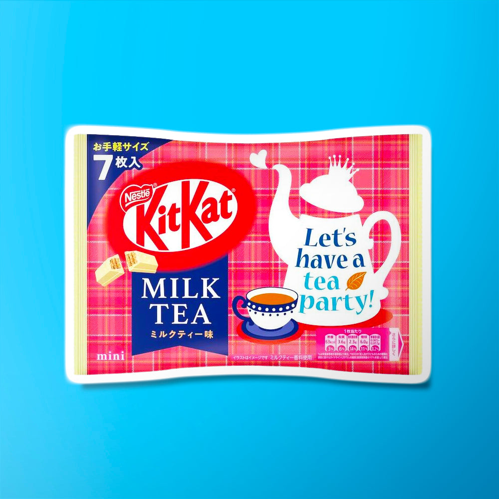 Un grand paquet rose aux extrémités couleur crème, au centre il y a une tasse de thé et une théière blanche et tout à gauche un biscuit enrobé de chocolat blanc. Le tout sur fond bleu