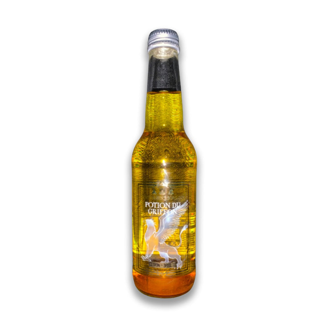 Une bouteille transparente avec une boisson pailletée jaune et sur l’étiquette une créature blanche avec des ailes et une queue. Le tout sur fond blanc