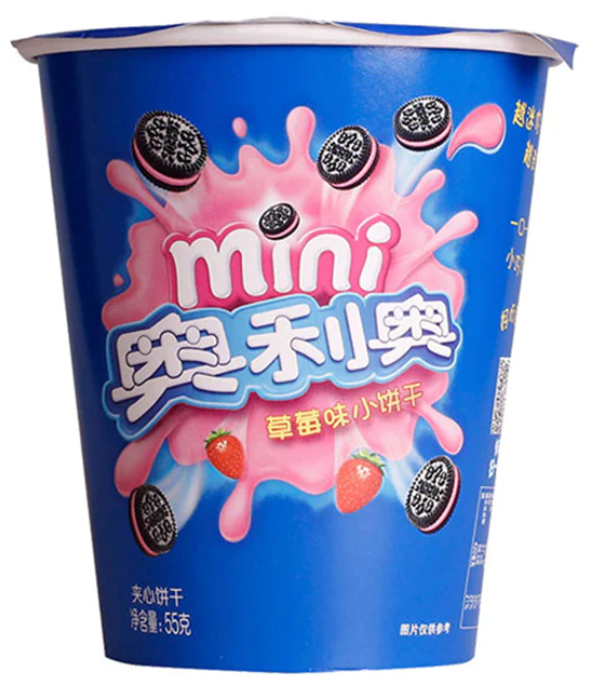 Un emballage bleu avec une explosion de liquide rose avec des fraises et des biscuits noirs. Le tout sur fond blanc