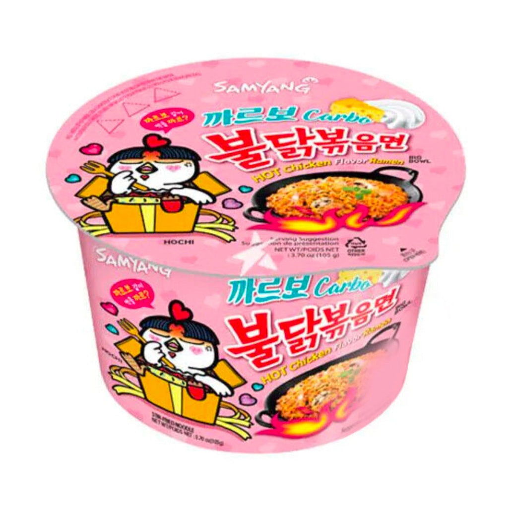 Un emballage en bol rose sur fond blanc avec à gauche une petite créature blanche dans un sac orange et à droite une poêle noire de nouilles jaunes