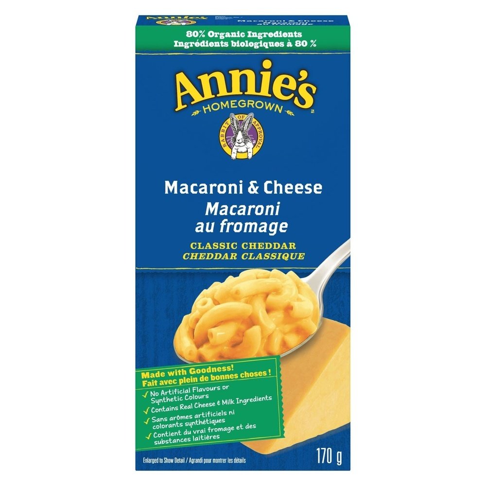 Un paquet bleu sur fond blanc avec au centre une cuillère de Mac&Cheese crémeux et à l’arrière un morceau de fromage 