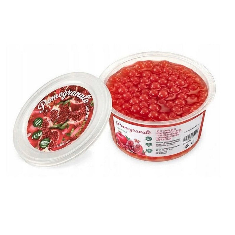 Une boite sur fond blanc remplie de perles rouges et à gauche le couvercle avec plusieurs grenades. Devant des perles rouges dans une cuillère