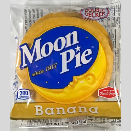 Un emballage transparent avec une lune jaune dans un ciel bleu et écrit « Banana » sur fond jaune sur une table blanche 