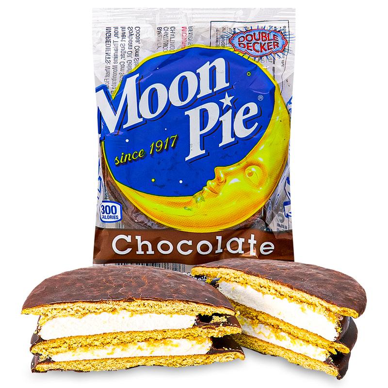 Un emballage transparent avec une lune jaune dans un ciel bleu et écrit « Chocolate » sur fond marron sur un fond blanc et devant 2 gâteaux au chocolat coupés en 2