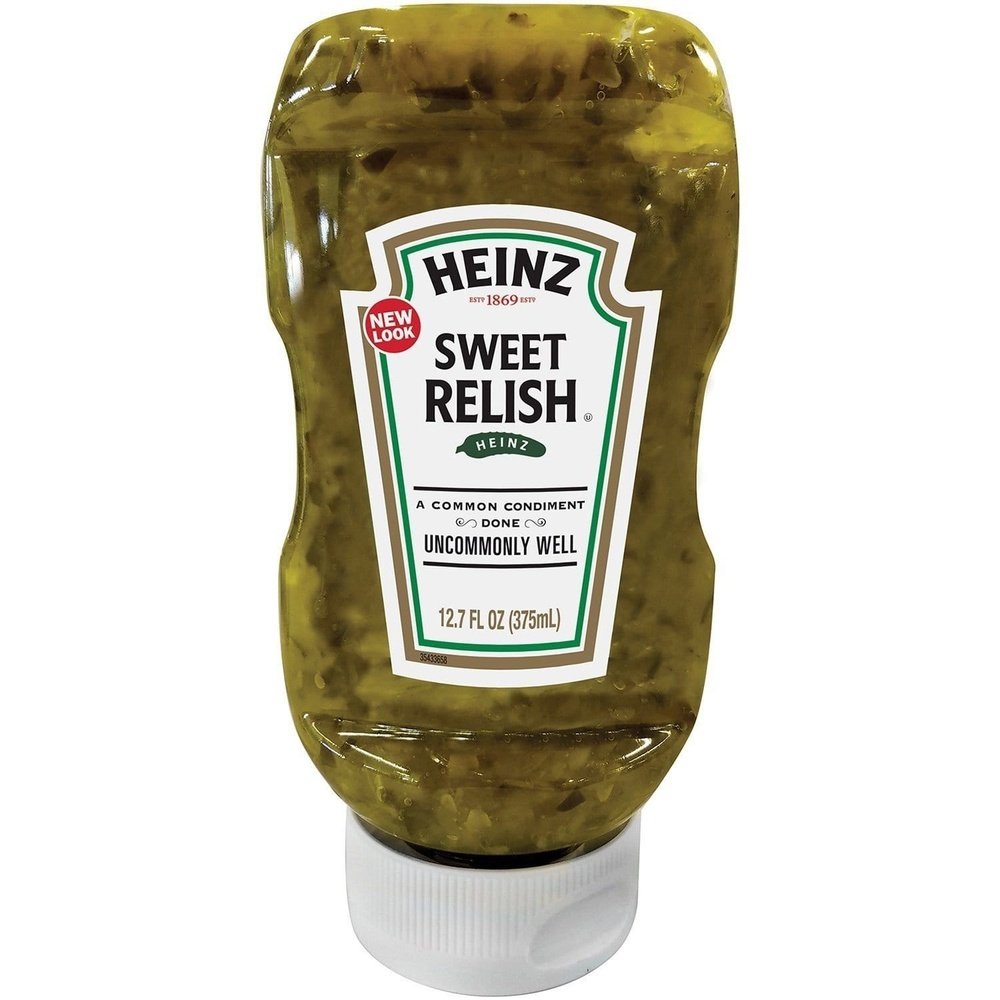 Un emballage de sauce transparent avec une sauce verte sur fond blanc et au centre une étiquette blanche
