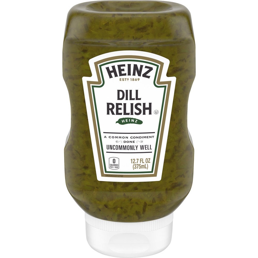Une bouteille transparente d’une sauce verte avec des morceaux vert foncé, un capuchon blanc et une étiquette blanche au centre. Le tout sur fond blanc