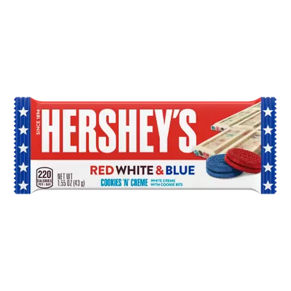 Un emballage blanc et rouge avec des extrémités bleues avec des étoiles blanches, sur le côté droit il y a une tablette de chocolat blanc avec des biscuits ronds bleu et rouge. Le tout sur fond blanc