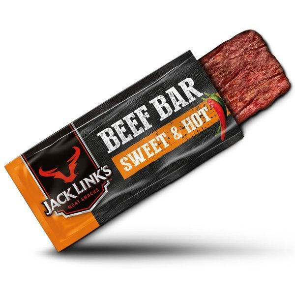 Un emballage orange et noire en oblique avec à gauche le symbole d’un taureau rouge et à droite un morceau de viande séchée en bar, le tout sur fond blanc