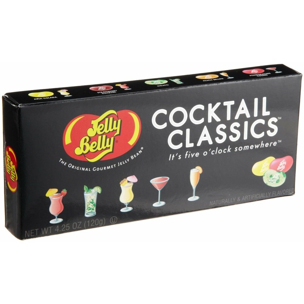 Un paquet noir de forme rectangulaire sur fond blanc avec 5 cocktails en bas à gauche et à droite 3 bonbons en formes d’haricots jaune, rouge et vert 