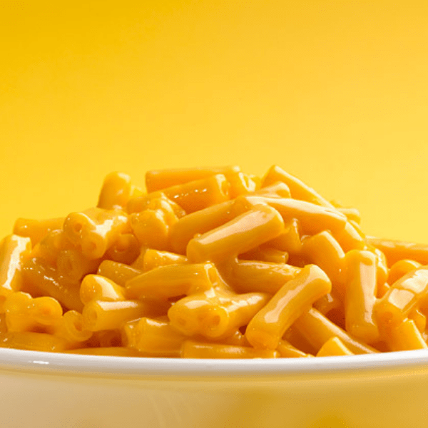 Un bol de macaroni au fromage avec un fond jaune derrière