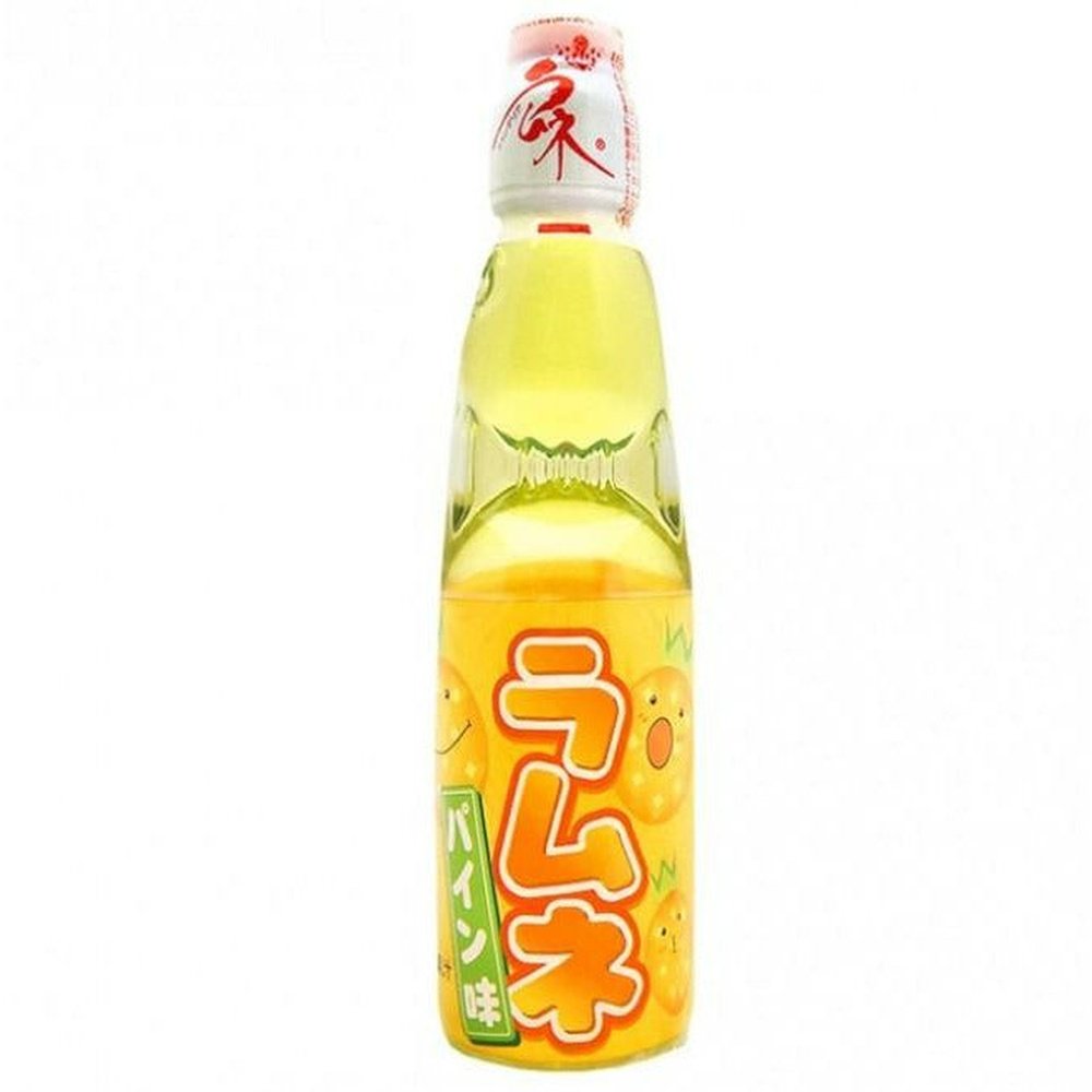 Une bouteille transparente sur fond blanc avec une boisson légèrement jaune, il y a une étiquette orange sur la moitié basse de la bouteille. Il y a des ananas qui sourient