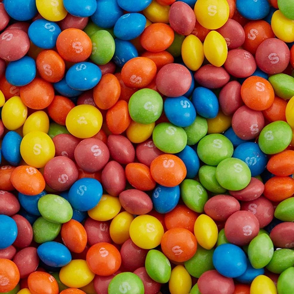 Un tas de Skittles jaune, rouge, orange, bleu et vert