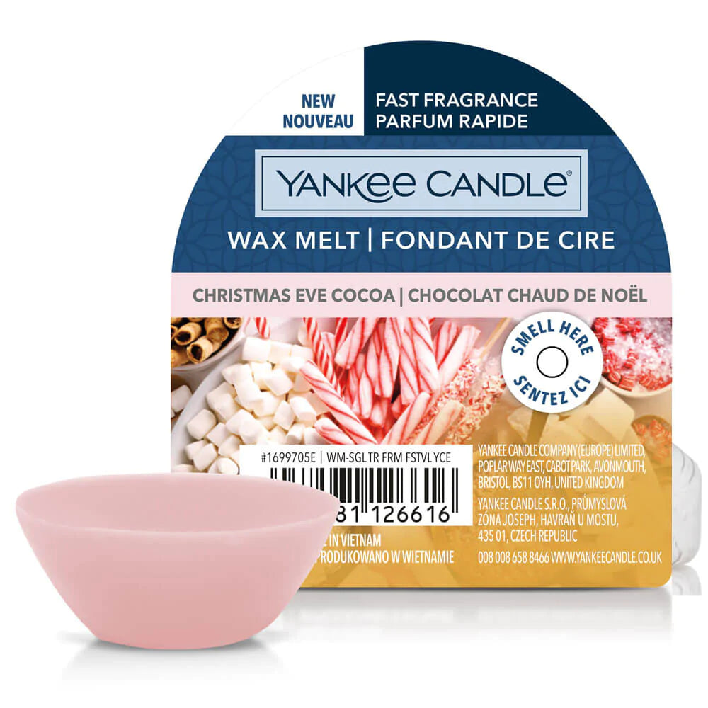Un emballage sur fond blanc avec un plateau de marshmallows blancs, de bonbons rouges et blancs et devant il y a un petit bol de cire rose